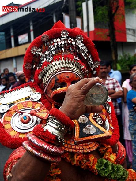 Theyyam, performer drinking water -Athachamayam 2013