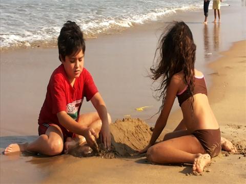 Innocent and cute kids playing on the shore.